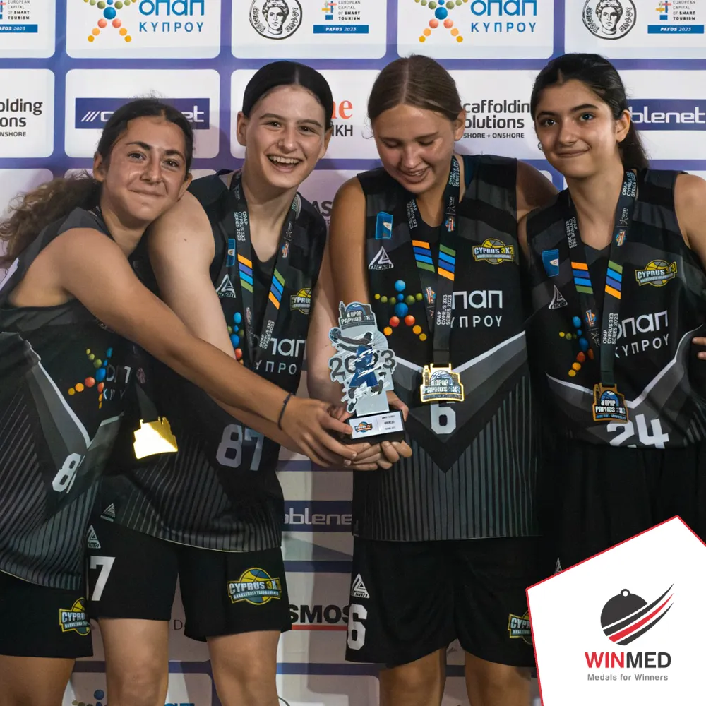 A group of female basketball players holding a basketball trophy