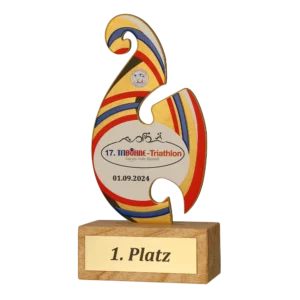 A vibrant first-place triathlon award with a red, blue, and yellow design mounted on a wooden base, inscribed with event details.