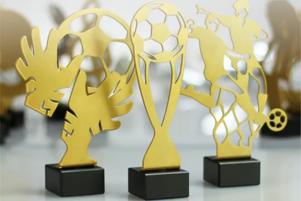 A set of gold football-themed trophies with black bases, showcasing various football designs.